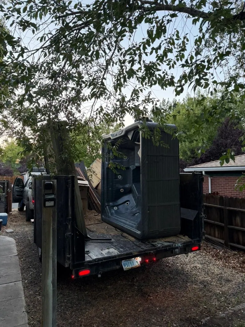 An old hot tub loaded upright on a trailer