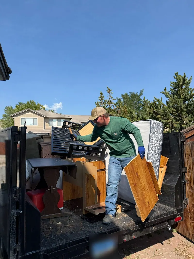 A crew member loading furniture and a mattress into the trailer