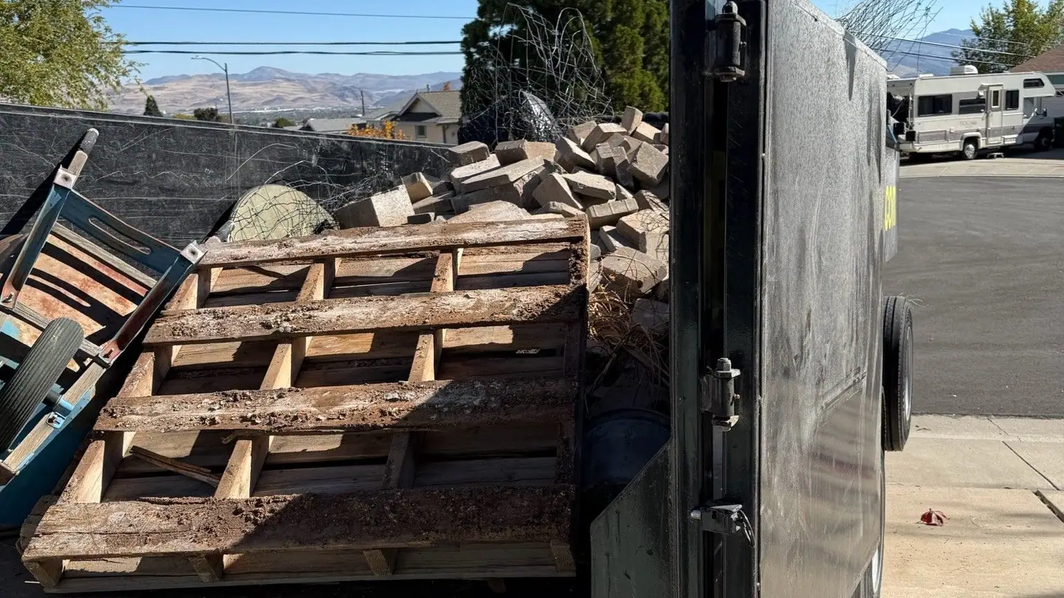 The dump trailer loaded with old pallets and scrap wood