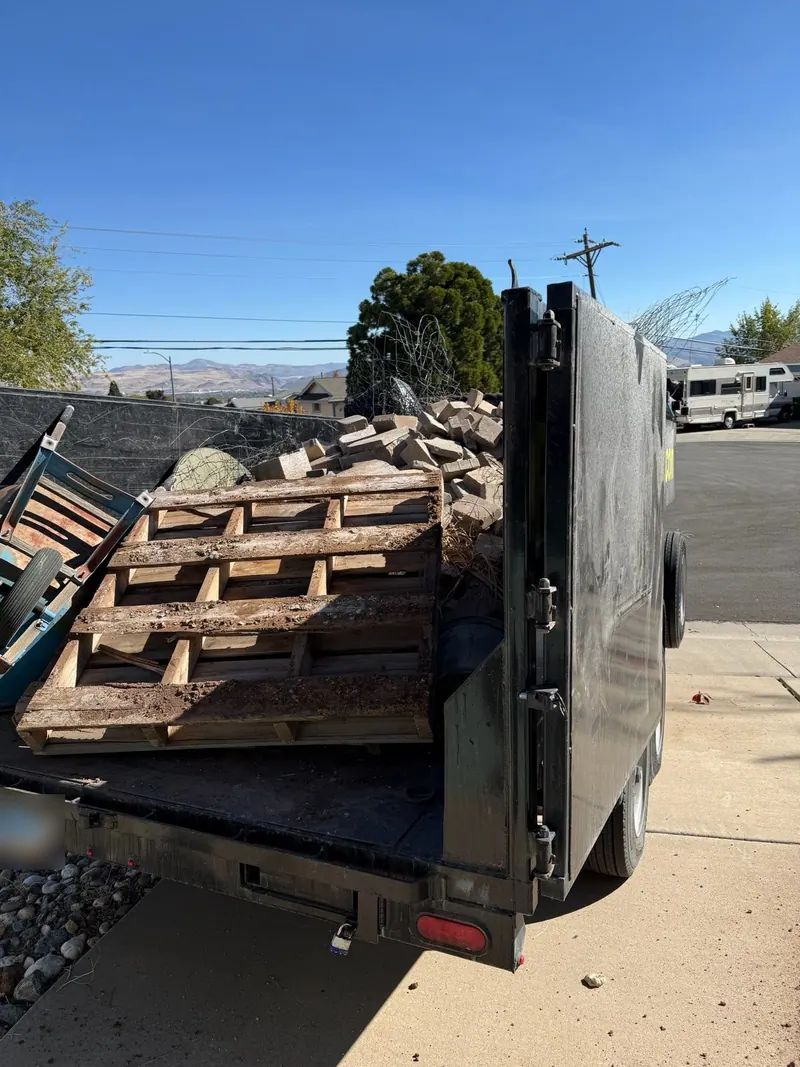 The dump trailer loaded with old pallets and scrap wood