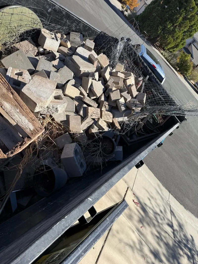The dump trailer loaded with old pavers and blocks