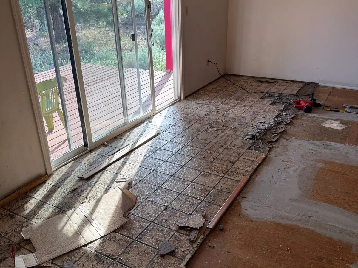 A room with old tile half pulled up from the floor