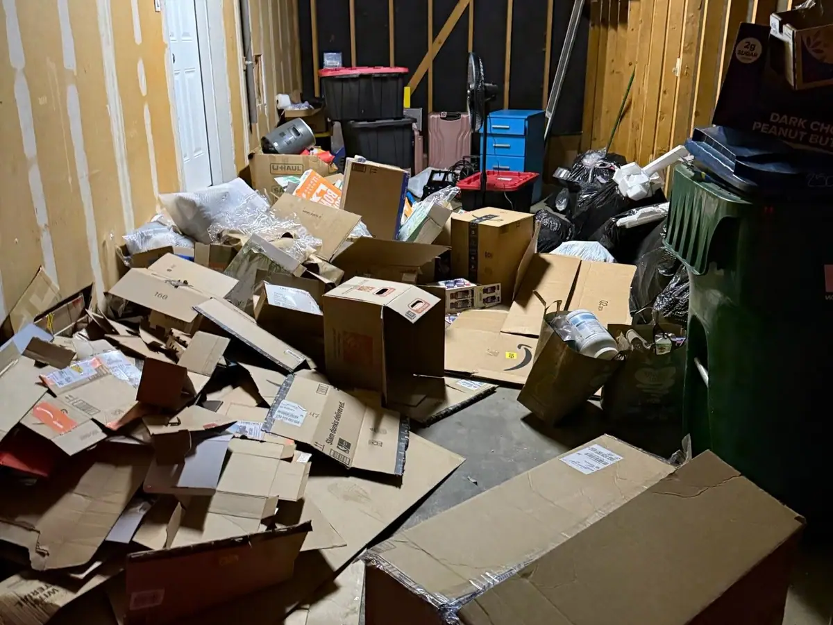 A storage unit floor covered in loose cardboard boxes