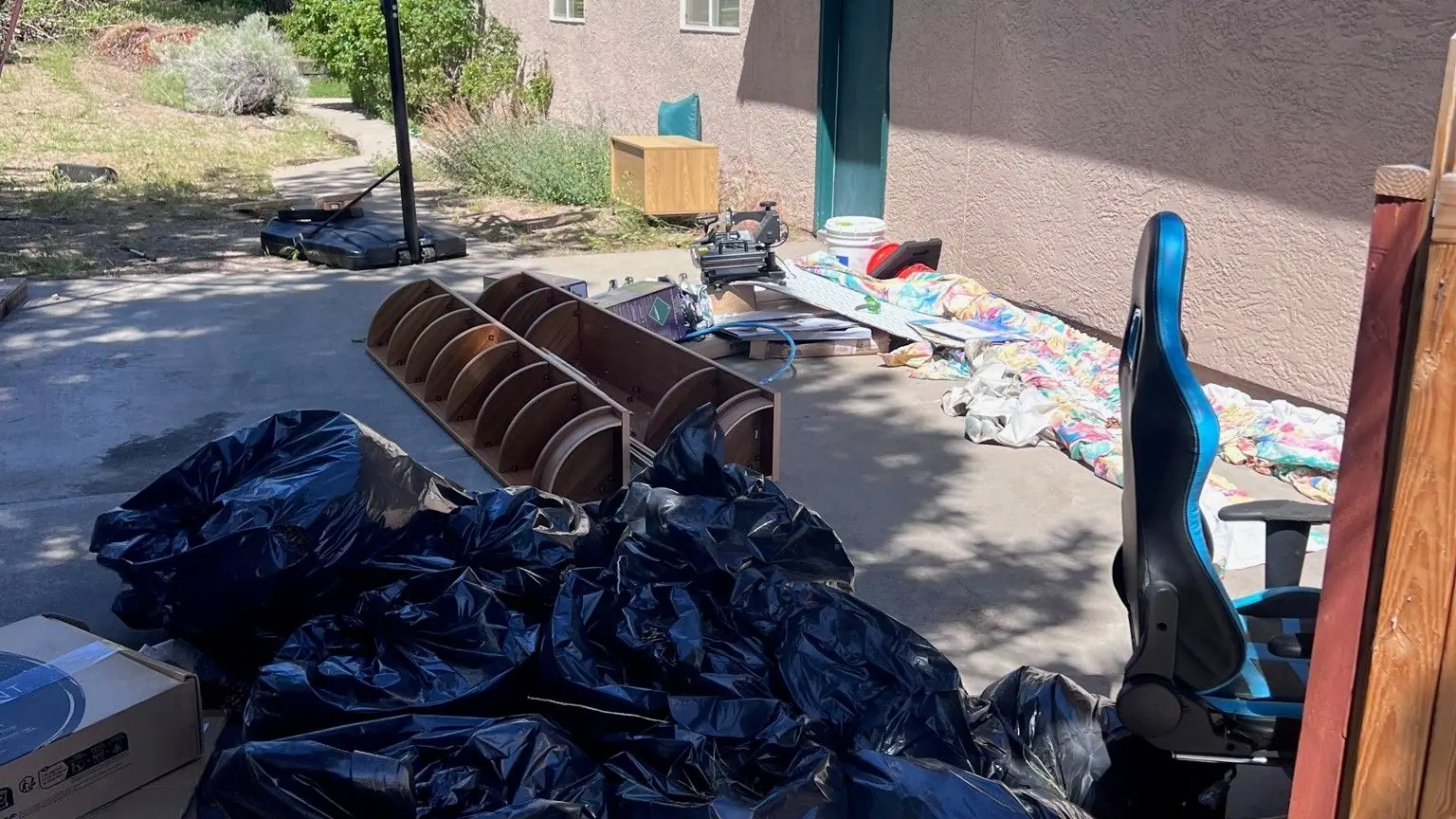 Trash bags and boxes piled beside a house