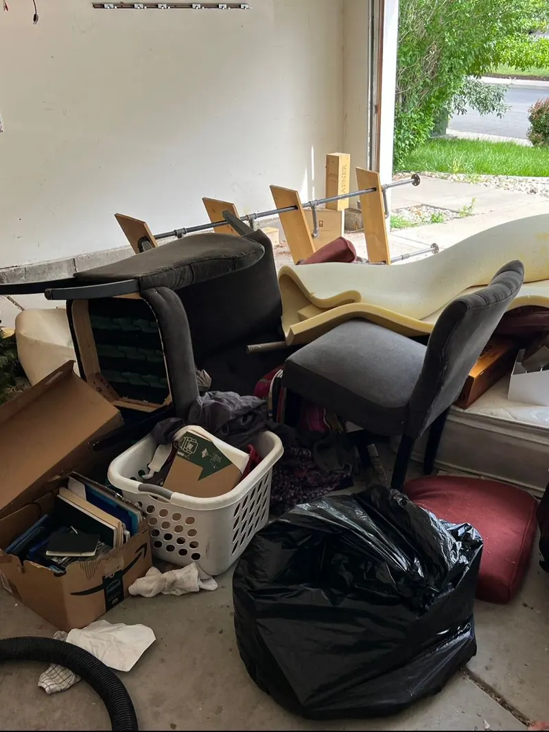 A garage packed with chairs bags and boxes