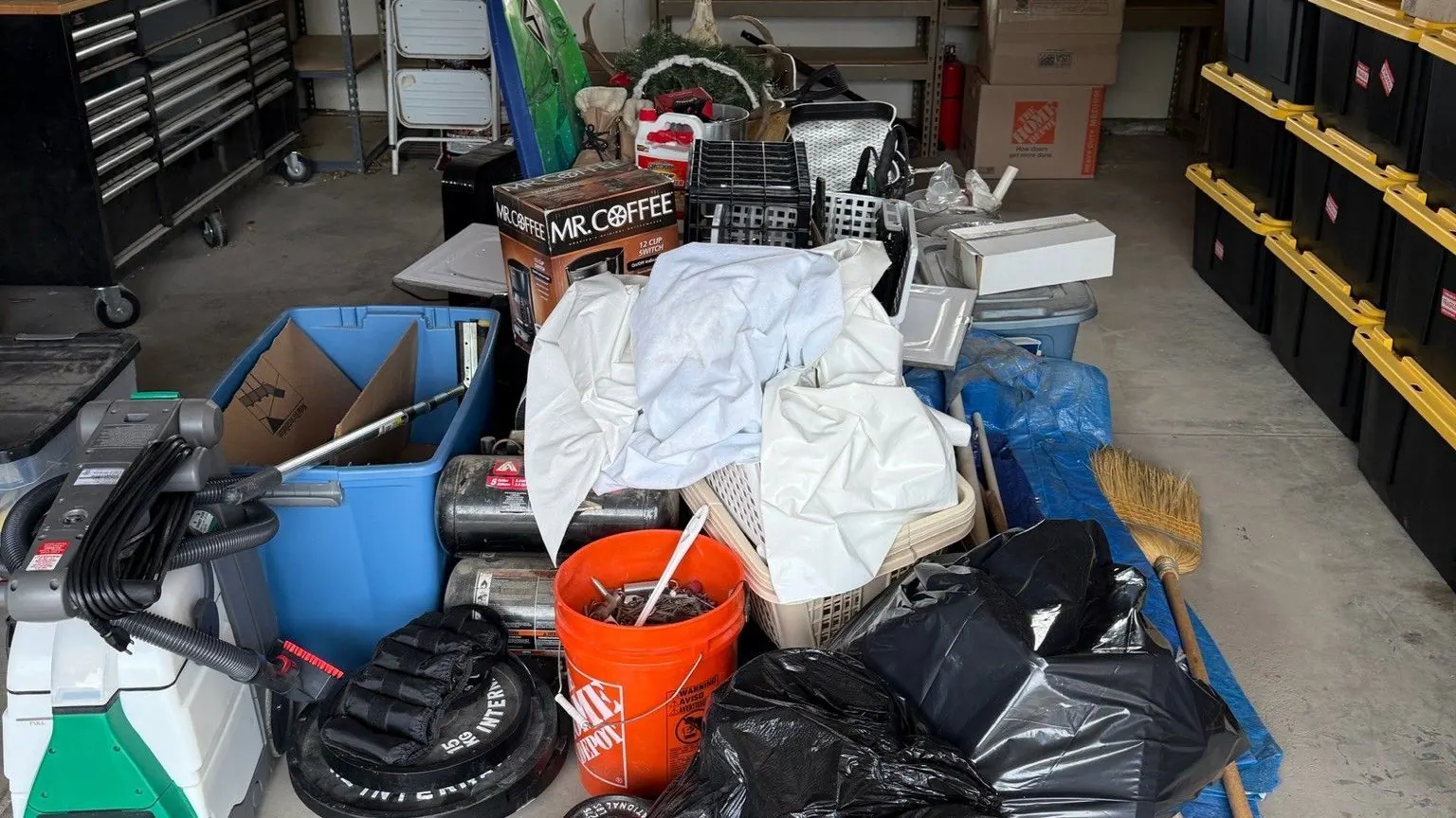 A shop garage floor covered in bags buckets and tools
