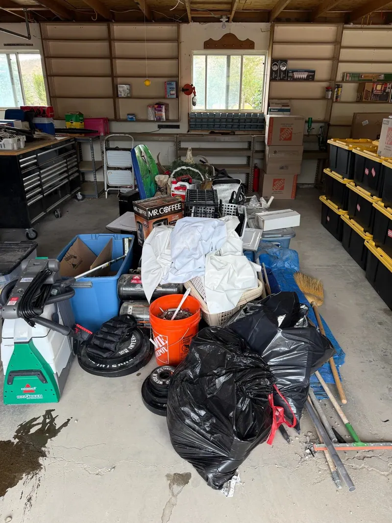 A shop garage floor covered in bags buckets and tools