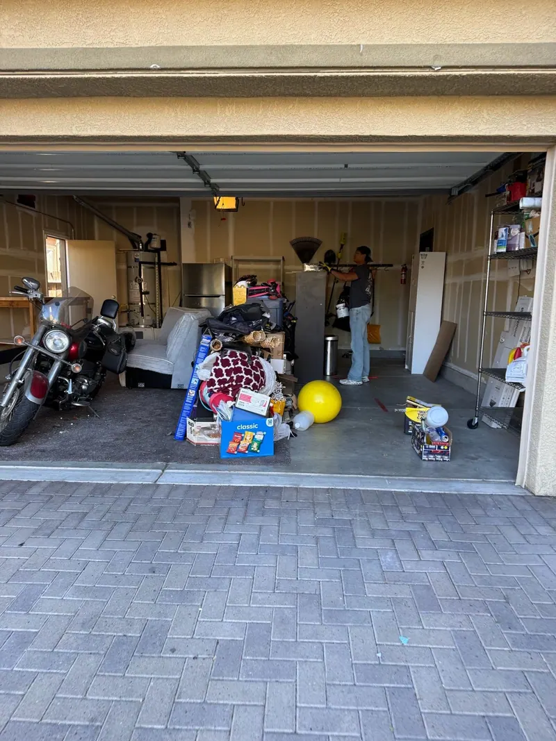 A garage full of household items with a motorcycle parked inside