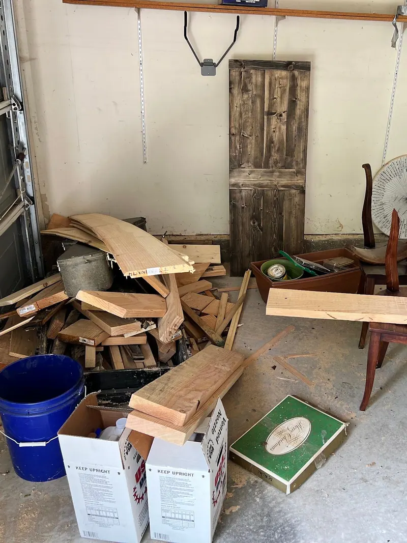 A garage floor covered in old furniture boxes and scrap wood