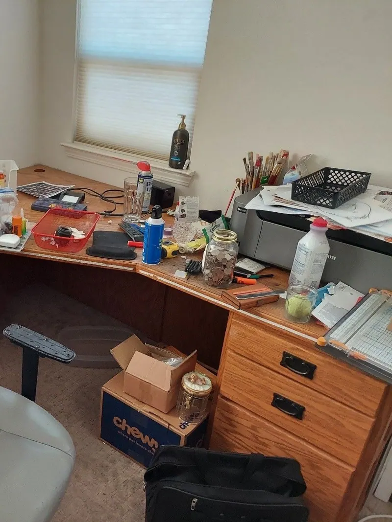 An office corner desk and chair covered in supplies