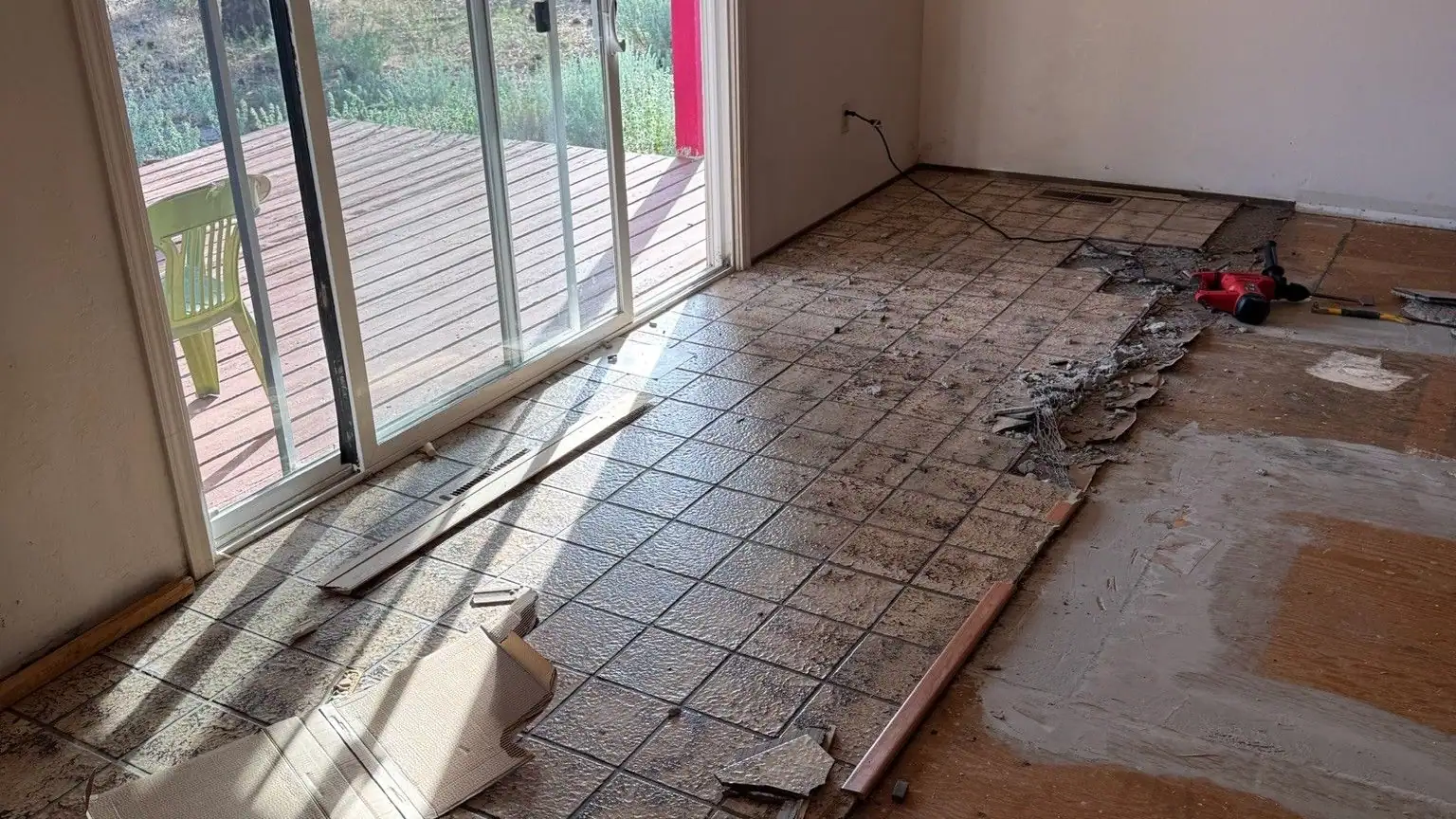 A room with old tile half pulled up from the floor